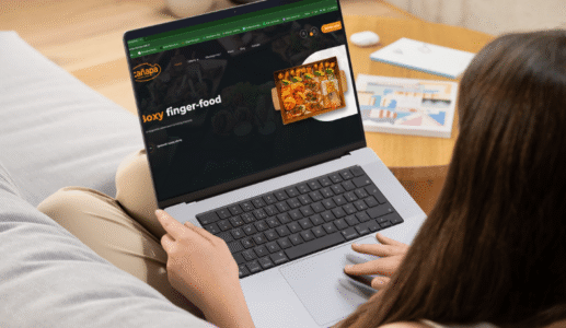 Kobieta przy komputerze przegląda ofertę cateringu biznesowego z dowozem w Bydgoszczy i okolicach.